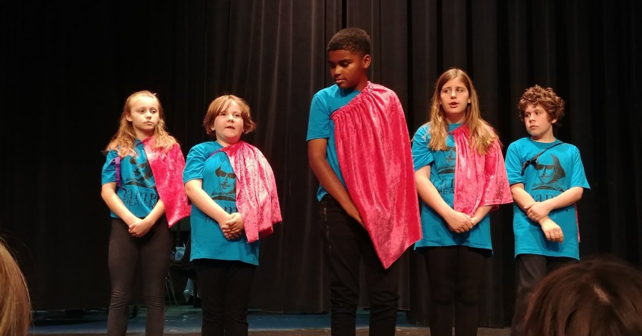 Five children wearing capes