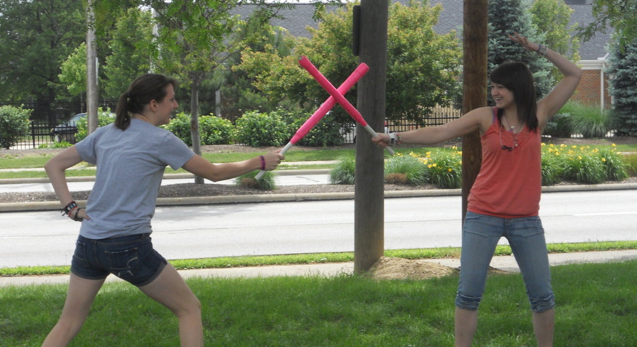 Two teens playing with foam swords